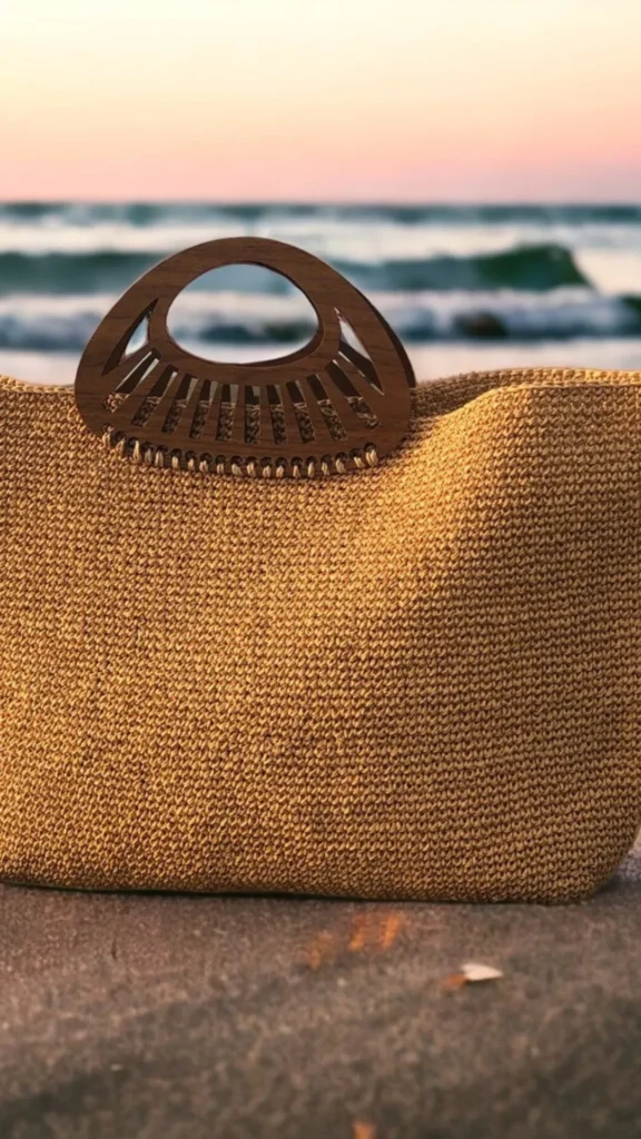 A flat-lay close-up of a rustic, circular woven wicker basket handbag resting on a dark surface. The bag features an open-weave design with vertical and horizontal woven straw details, matching structured top handles, and small woven spherical feet on its base. Inside the handbag, a soft cream-colored linen fabric lining protects the contents.