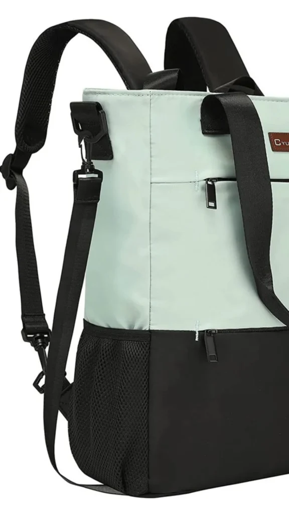 An image from file "5_19.webp" showing a close-up, three-quarter view of a convertible backpack tote against a plain white background. The bag features a two-tone color block design, with a light mint green nylon fabric on the upper portion and solid black material on the lower section. It includes thick black webbed tote handles on top and structured black padded backpack straps with breathable mesh undersides arching from the back. A black mesh water bottle pocket is attached on the lower left side, and multiple zippered compartments with slim black pulls are visible on the front face. A detachable black webbed shoulder strap is secured to the side hardware with a plastic swivel snap hook.